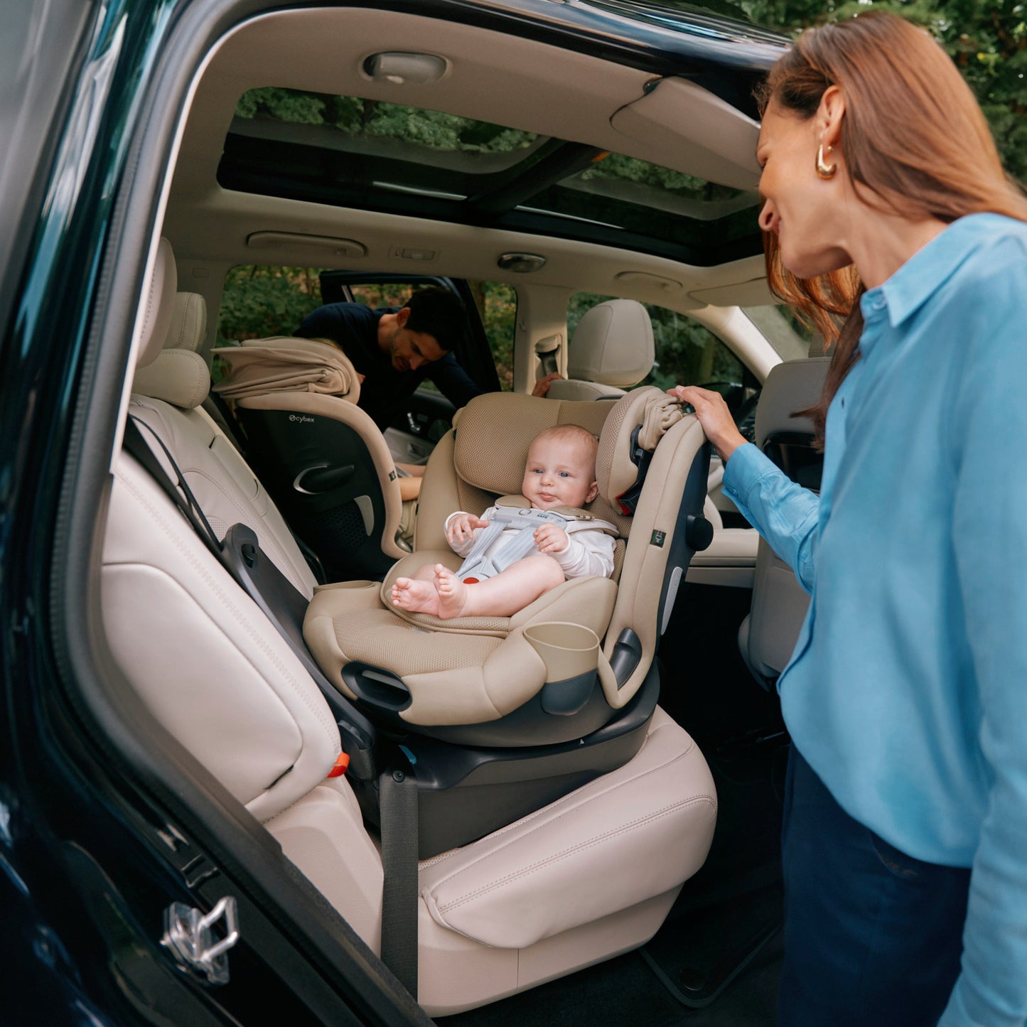 Woman securing a baby in a callisto car seat inside a vehicle