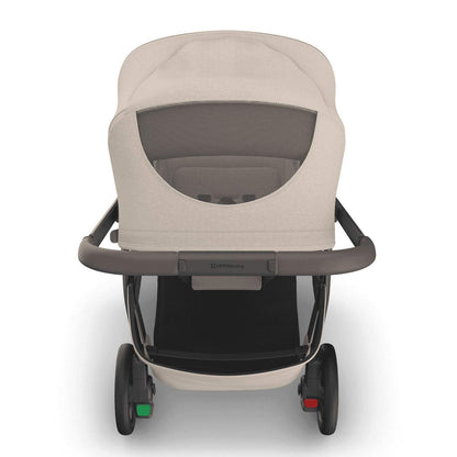 
Rear view of a beige baby stroller with a mesh peek-a-boo window in the canopy, set against a white background.