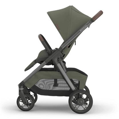 
Side profile of an olive green baby stroller with a grey frame, sun canopy, and storage basket, isolated on a white background.