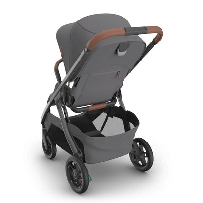
Three-quarter rear view of a grey baby stroller with brown leather accents and a storage basket, isolated on a white background.