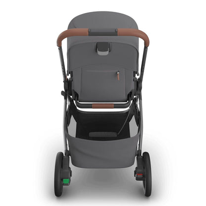 
Rear view of a grey baby stroller with brown leather handle grip and storage basket, isolated on a white background.