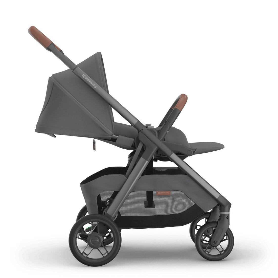 
Side profile of a reclined grey parent-facing baby stroller with brown leather handle grips, isolated on a white background.