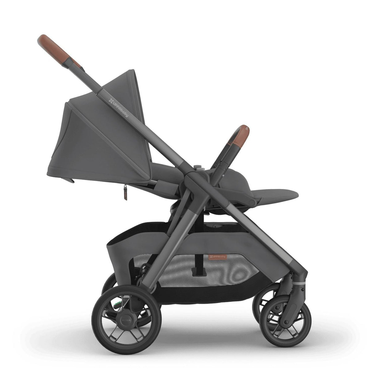 
Side profile of a reclined grey parent-facing baby stroller with brown leather handle grips, isolated on a white background.