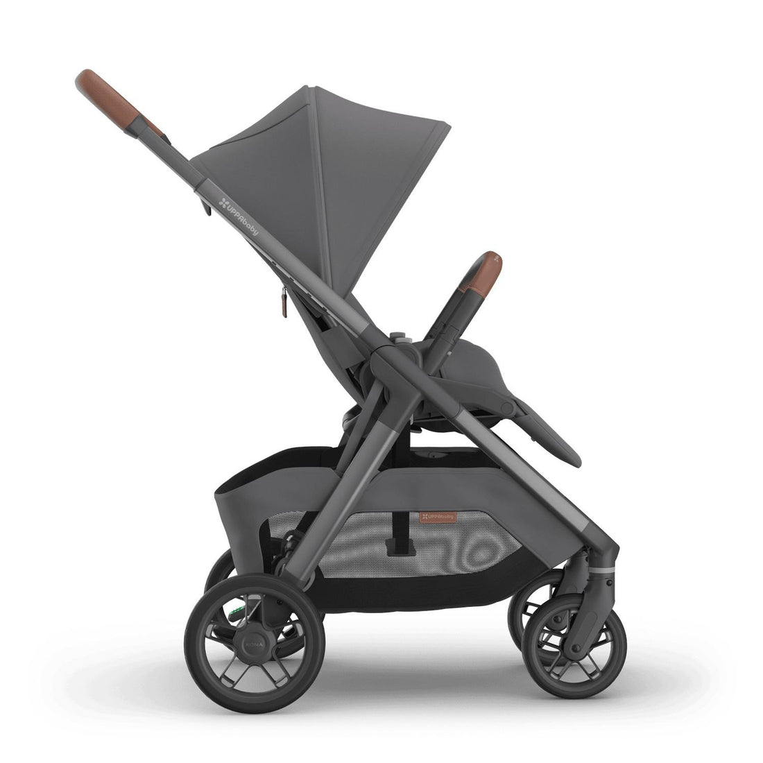 
Side profile of a grey forward-facing baby stroller with an extended sun canopy and brown leather handle grips, isolated on a white background.