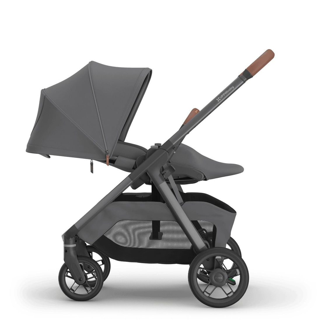 
Side profile of a reclined grey parent-facing baby stroller with an extended sun canopy and brown leather handle grips, isolated on a white background.