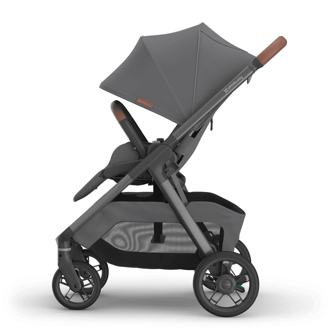 
Side profile of an upright grey forward-facing baby stroller with an extended sun canopy and brown leather handle grips, isolated on a white background.