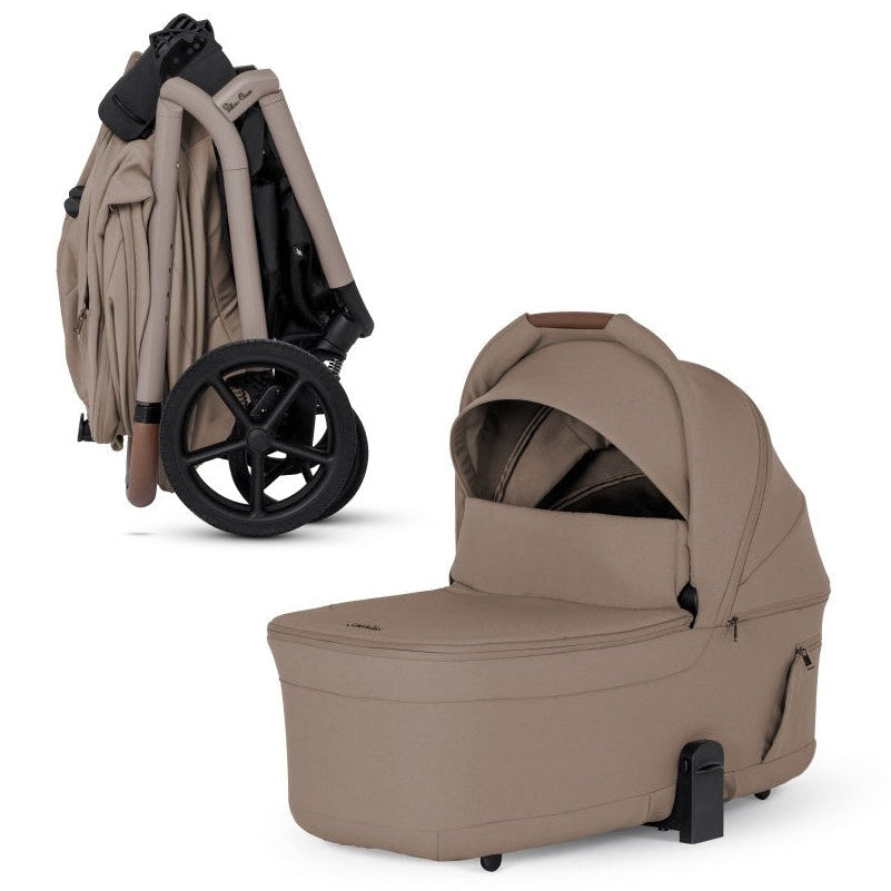 A tan stroller shown compactly folded alongside its matching standalone tan bassinet.