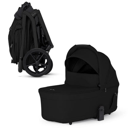 An all-black stroller shown compactly folded alongside its matching standalone black bassinet.