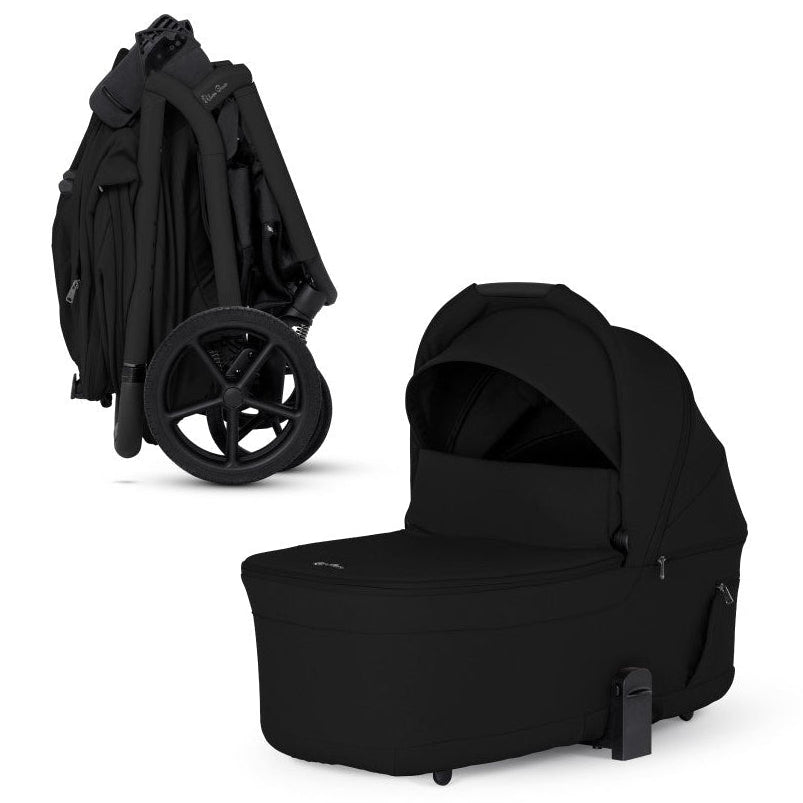 An all-black stroller shown compactly folded alongside its matching standalone black bassinet.