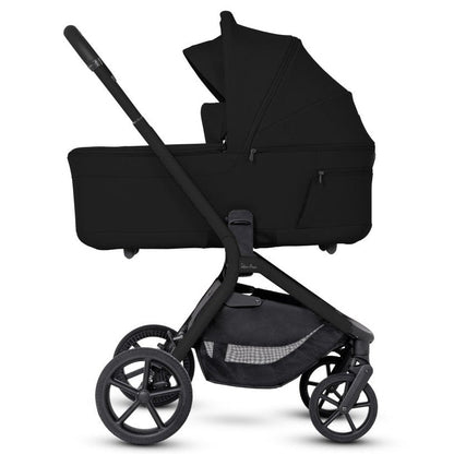 Side profile of an all-black stroller frame with a black bassinet attached.