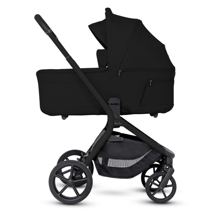 A side profile view of an all-black stroller configured in bassinet mode.