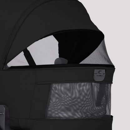 Close-up of a black stroller bassinet featuring extended mesh ventilation panels on the side and canopy.