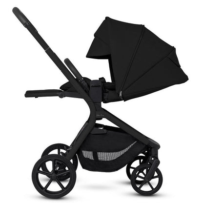 Side profile of an all-black stroller with its seat in a fully reclined position and the canopy extended.