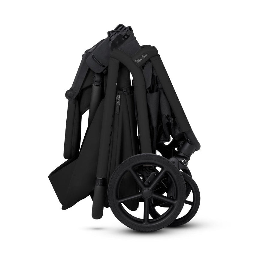 A side view of a compactly folded all-black stroller standing upright.