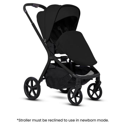 An all-black stroller fitted with a newborn apron, accompanied by informational text overlay at the bottom.