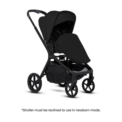 An open all-black stroller fitted with a newborn apron cover.