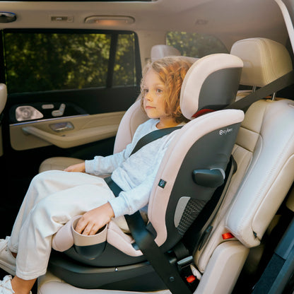 Child in a callisto car seat inside a vehicle with a blurred background