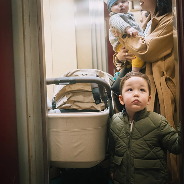 Joolz Hub² Compact Stroller with Carry Cot in Sandy Taupe Lifestyle Elevator Narrow View