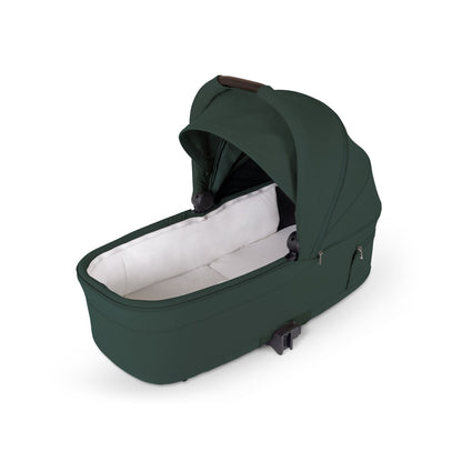 Dark green stroller bassinet with an open canopy and white interior lining.