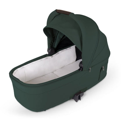 An olive green standalone stroller bassinet with an open canopy and white padded interior lining.