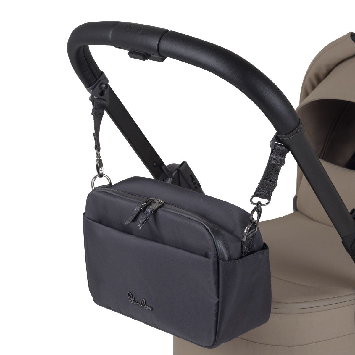 A black fabric stroller organizer bag hanging from a black leather handlebar by adjustable straps.