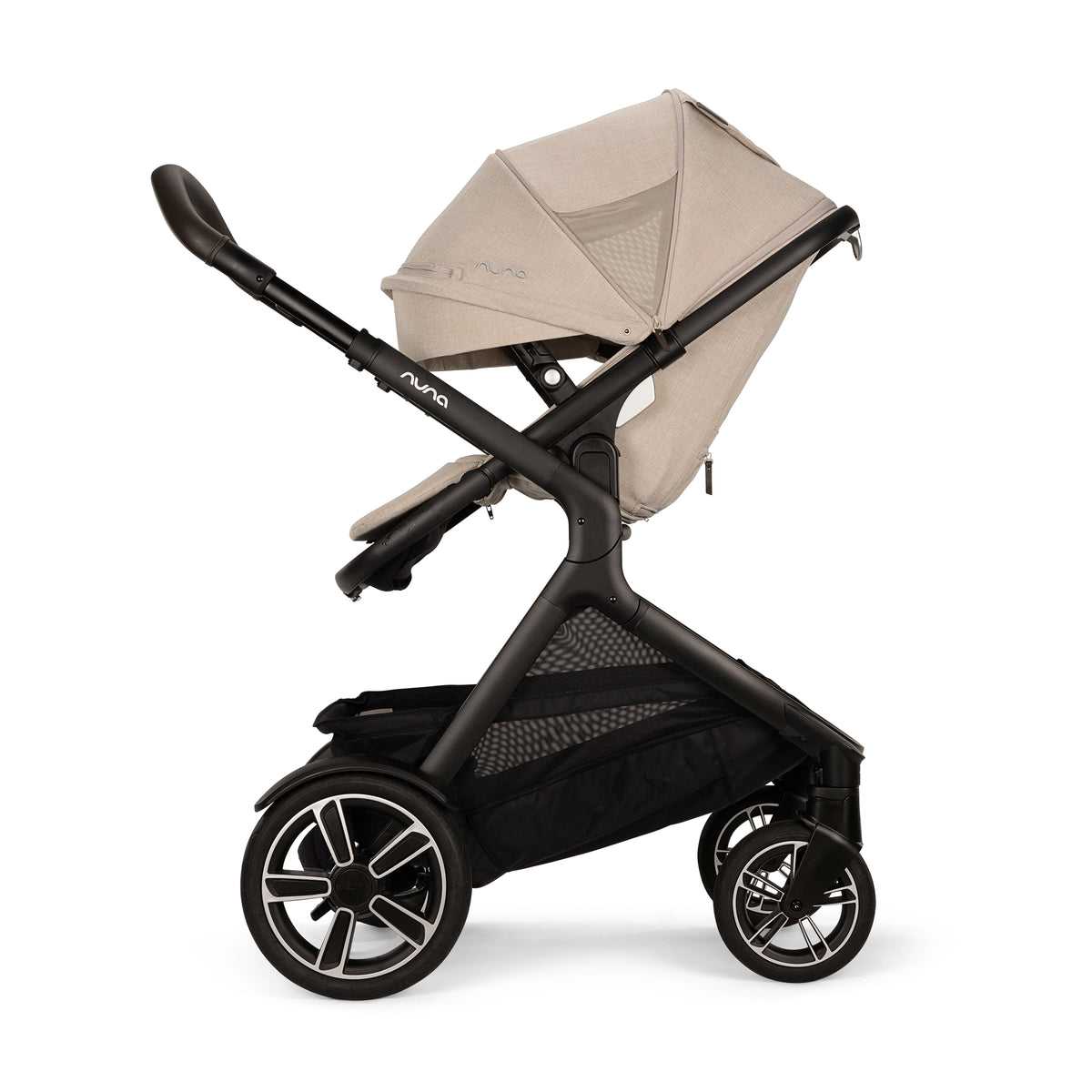 
A stroller with a black frame and a light beige canopy, shown from a side profile on a solid white background.