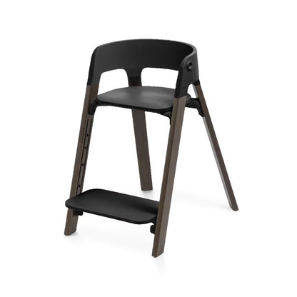 
A modern wooden step stool with a black plastic seat, backrest, and footrest, set against a plain white background.