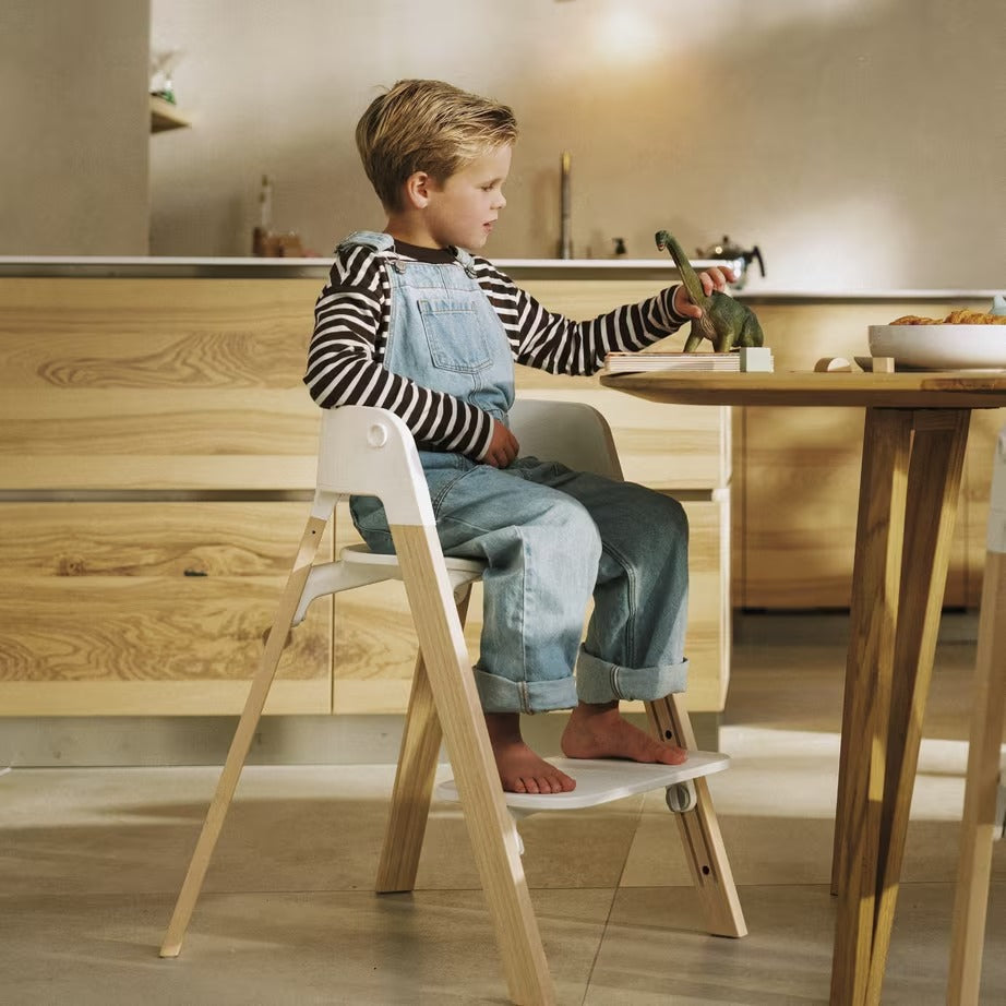 
Child sitting on a wooden step stool in a kitchen