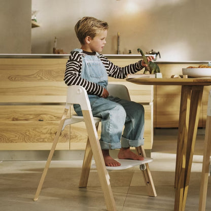 
Child sitting on a wooden step stool in a kitchen