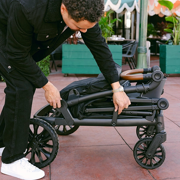 Wonderfold L4 Quad Stroller Wagon in Black Lifestyle Folded on Wheels
