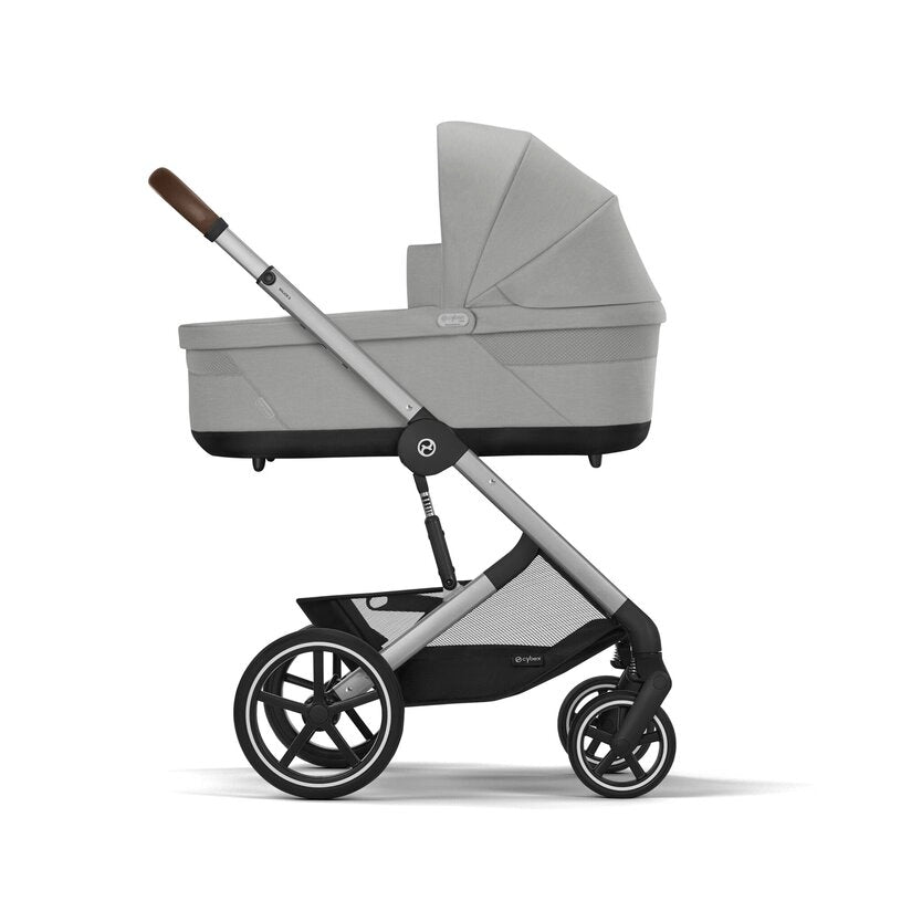 
Gray stroller with a folded baby carrier on a white background