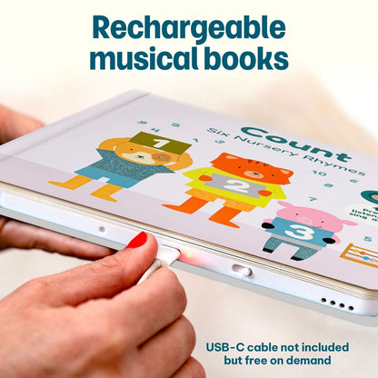 
Hands plugging a charging cable into a rechargeable "Count" children's musical book.
