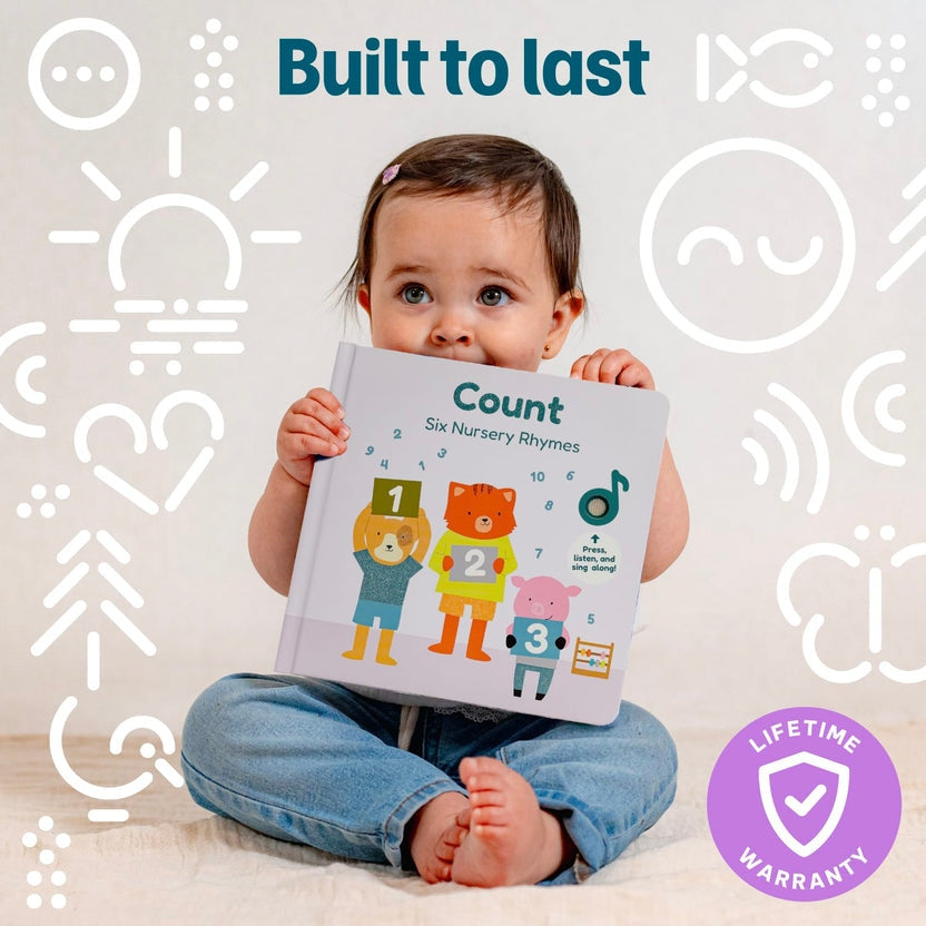 
A baby sitting on a light floor holds a hardcover children's book titled 'Count: Six Nursery Rhymes.' The baby is wearing blue jeans, and the background is a light off-white wall with white line icons and the text 'Built to last.
