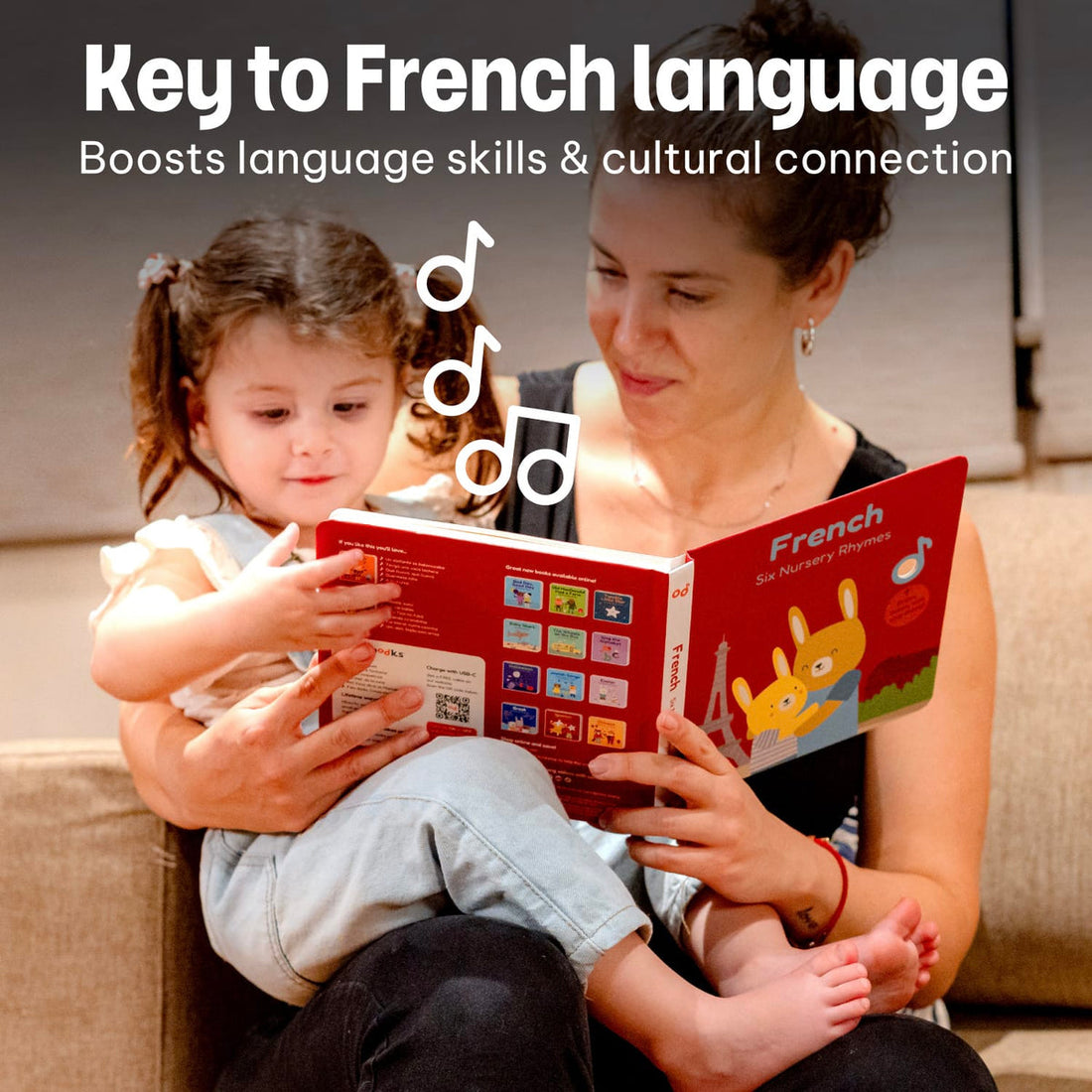 
A woman and young girl reading a colorful French nursery book together on a beige sofa. Large text at the top reads 'Key to French language' and 'Boosts language skills & cultural connection,' with musical note graphics floating between them.