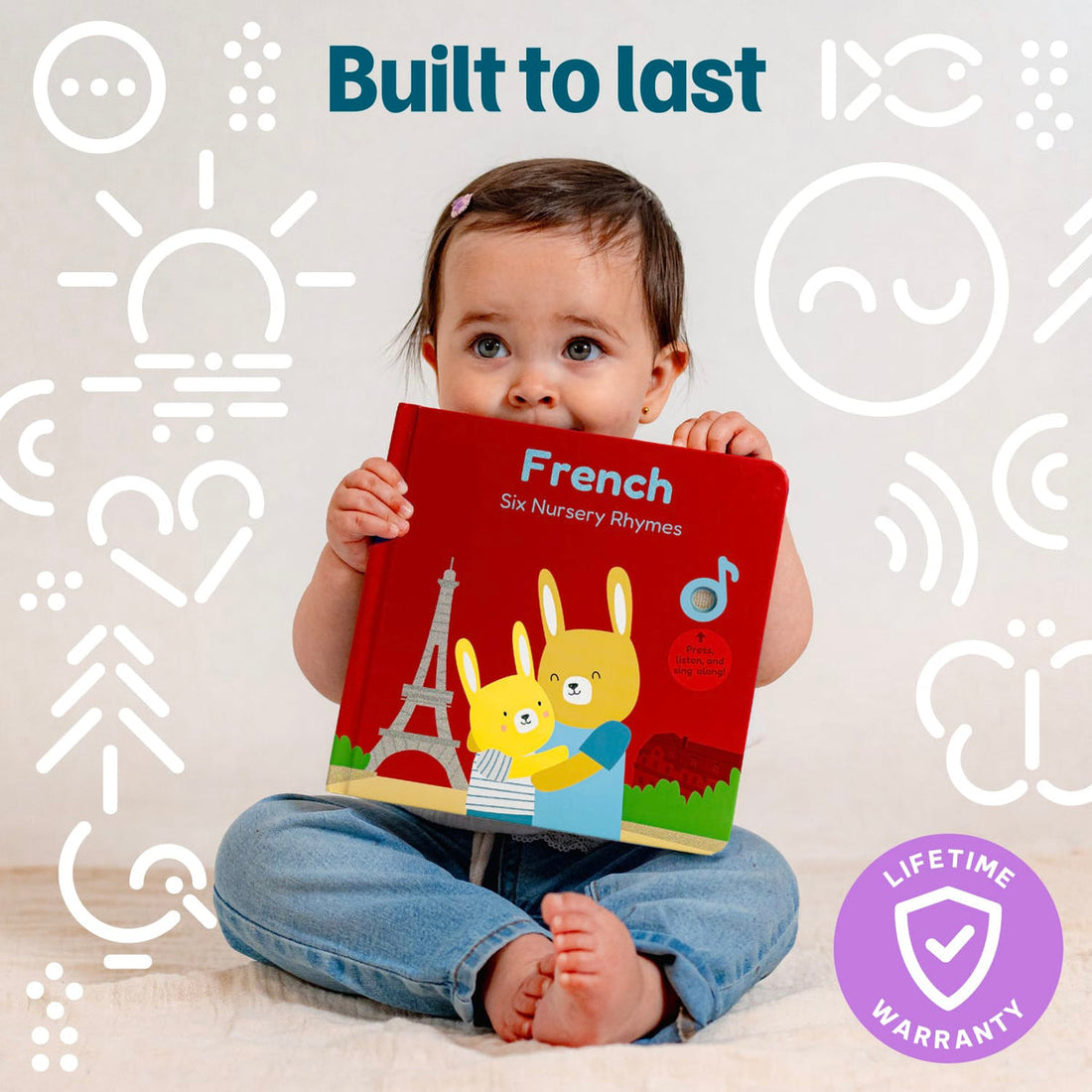 
A baby sitting on a light floor holding a red board book titled 'French Six Nursery Rhymes'. The background is white with white line icons and the text 'Built to last' at the top, and a purple 'Lifetime Warranty' badge at the bottom right.
