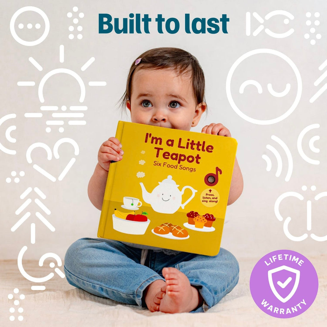 
A baby sitting cross-legged and holding a yellow interactive sound book titled "I'm a Little Teapot - Six Food Songs"