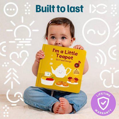 
A baby sitting cross-legged and holding a yellow interactive sound book titled "I'm a Little Teapot - Six Food Songs"