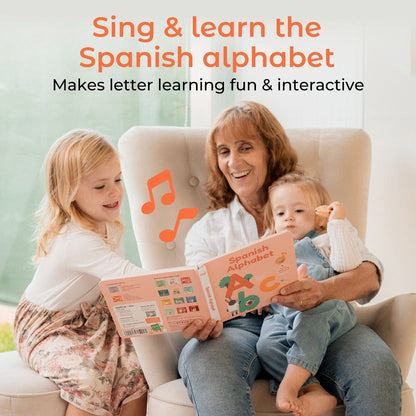 
Woman and two children reading a book titled 'Spanish Alphabet' with music notes on a couch.
