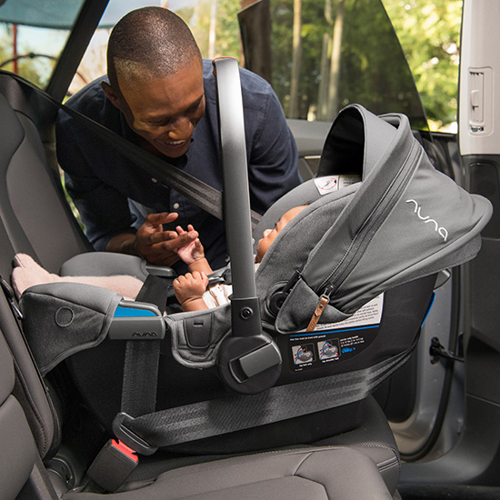 a man viewing a baby in the Nuna Pipa RX and Relx Base car seat